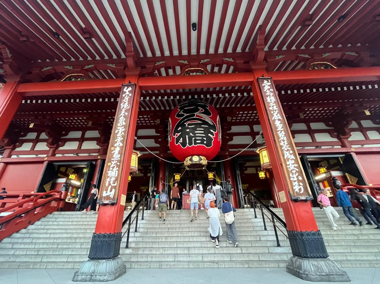 Templo Senso-ji en Asakusa, Tokio, con faroles rojos y visitantes caminando por la entrada principal.
