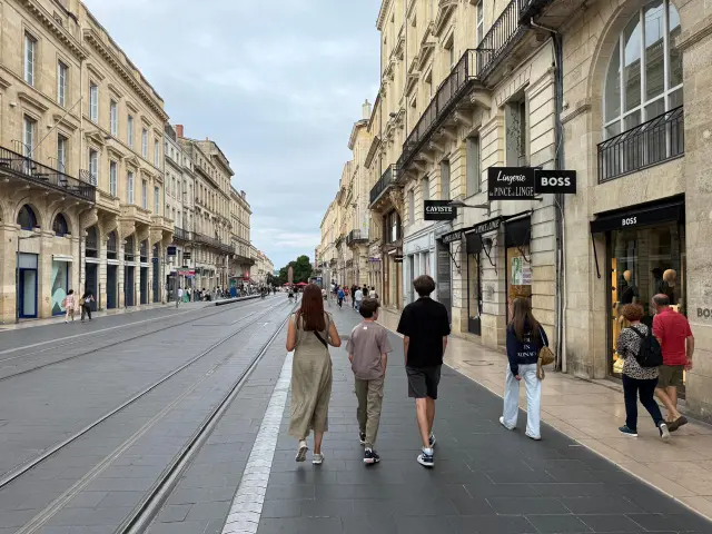 Caminando por Cours de l’Intendance en Burdeos, una de las avenidas más elegantes con boutiques de lujo y tranvía.