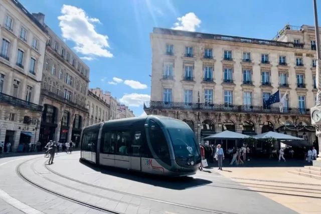Tranvía recorriendo el centro histórico de Burdeos, rodeado de edificios elegantes y plazas francesas.